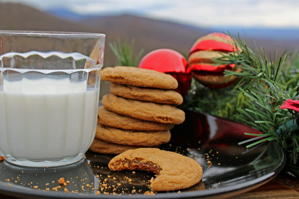 grandma's gingersnap cookies stacked on plate with glass of milk with Christmas decor