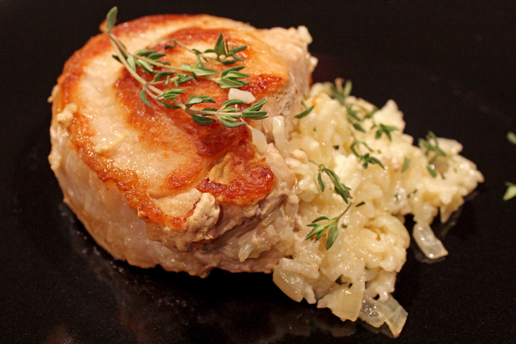 Cheesy rice stuffed pork chops on plate ready to eat