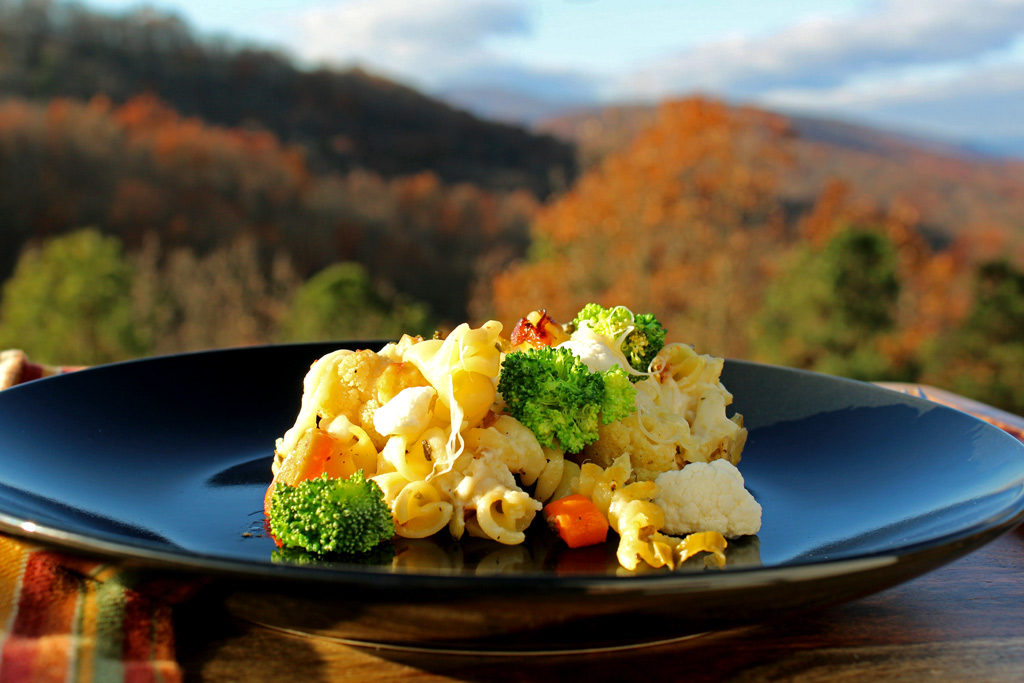 easy roasted vegetable pasta on a plate with mountain view