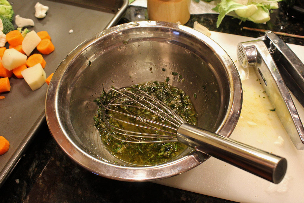 oil and herbs with whisk in bowl