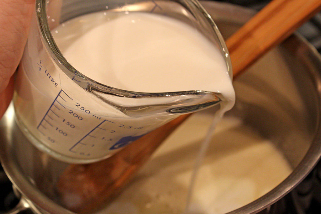 pouring milk into sauce