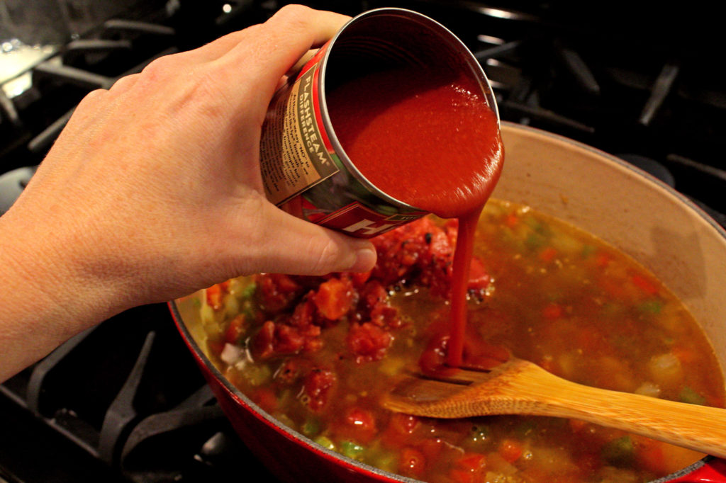 pouring tomato sauce into pan