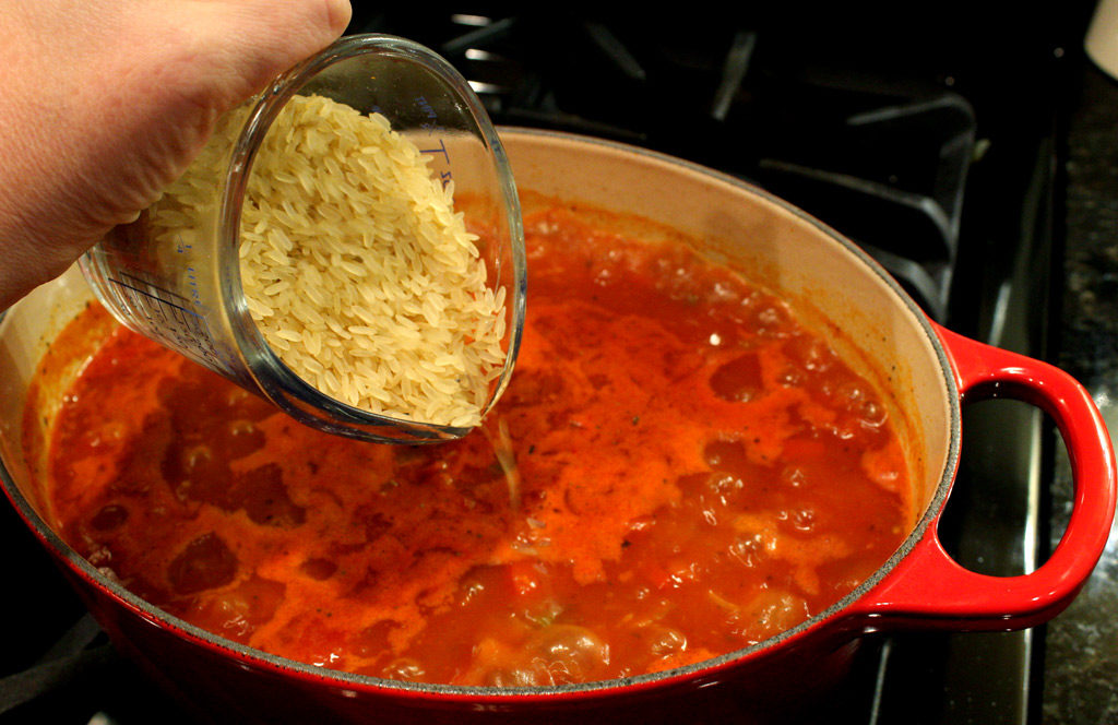 pouring rice into jambalaya