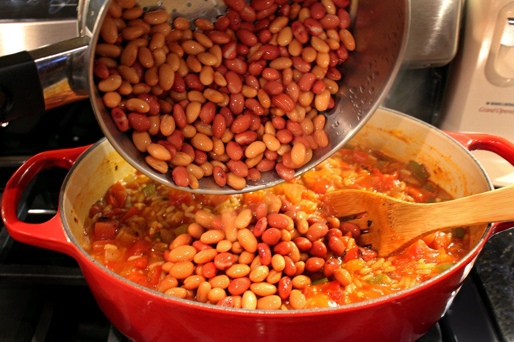 pouring rinsed and drained beans into pot