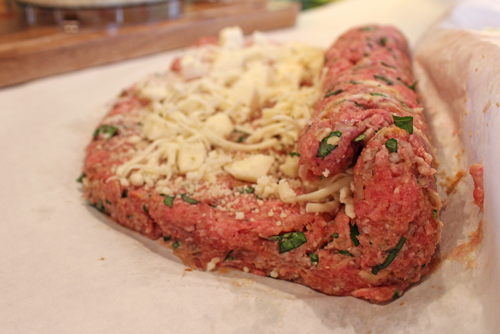 rolling the meat mixture around the cheese