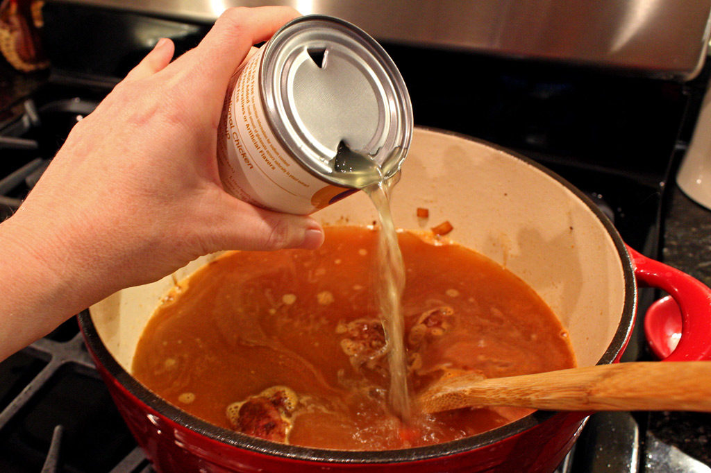 adding broth to pot