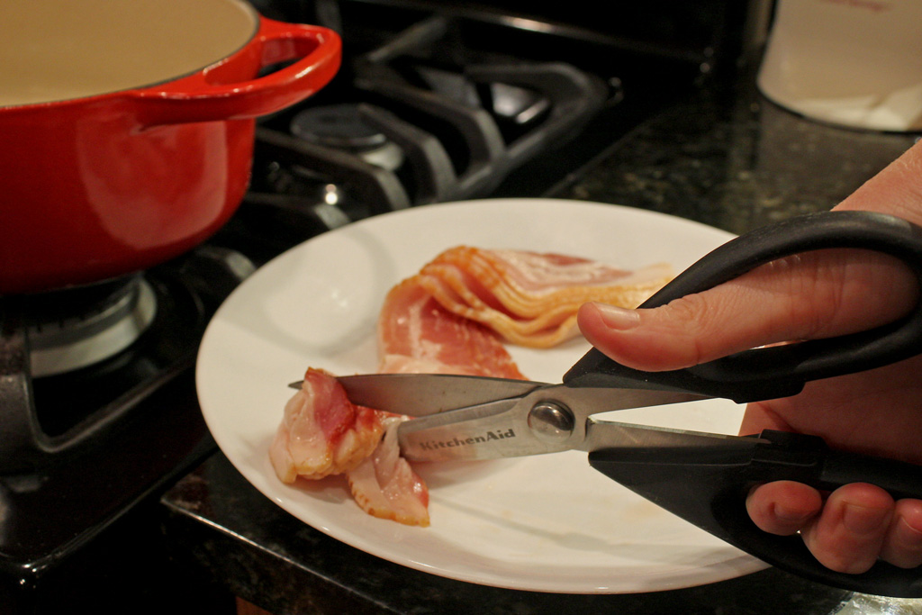 cutting raw bacon with scissors