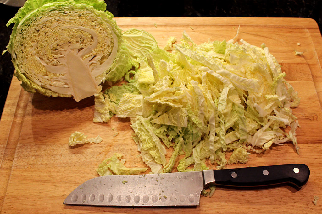 shredded cabbage on cutting board with knife