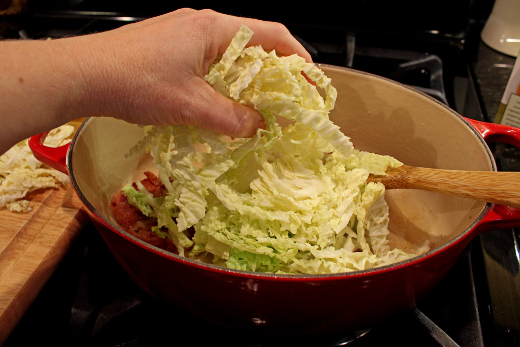 adding cabbage to Dutch oven