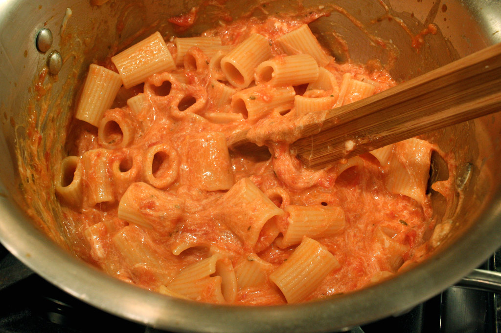 stirring cheese into pasta