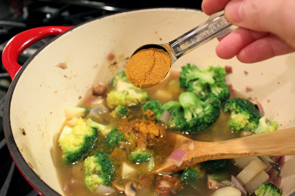 adding curry powder to the broccoli potato soup