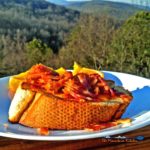 French bread egg in a basket is made with an egg cooked over easy inside a hole in the center, topped with melted cheese and sprinkled with bacon bits. Yum! | TheMountainKitchen.com