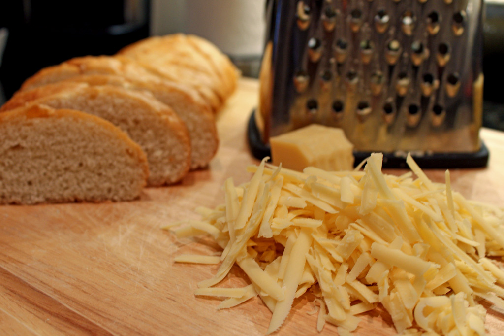 shredded cheese on cutting board with bread