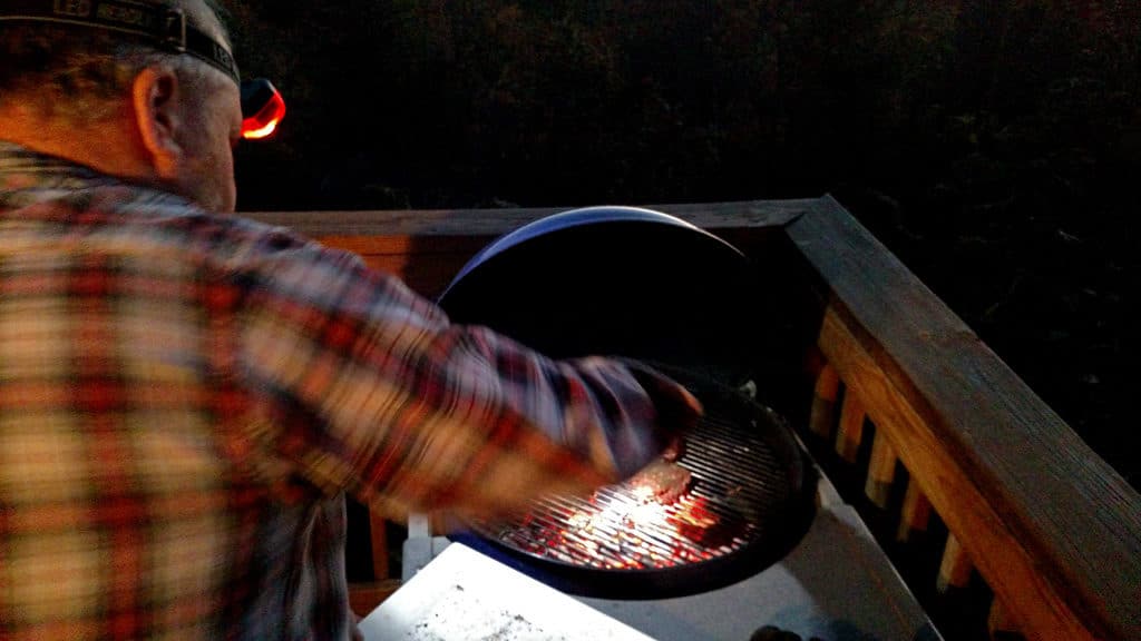 David using his headlamp to grill in dark