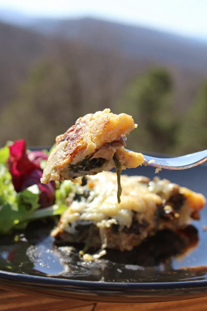 a bite of mushroom spinach quiche on fork