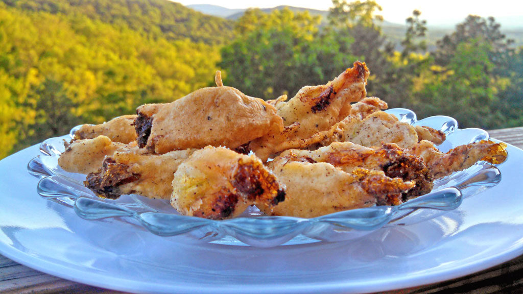 These delicate fried squash blossoms are filled with a creamy ricotta cheese mixture and dipped in a light batter, fried to a golden brown. They're amazing!