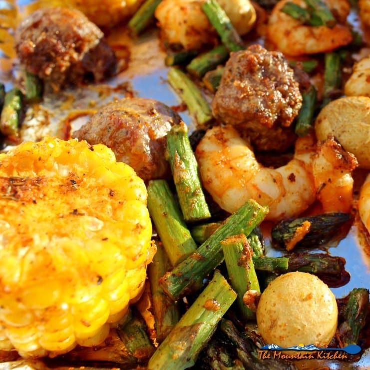 Cajun spiced shrimp, juicy andouille sausage, asparagus, potatoes and corn make up a flavorful meal in minutes. Make this Sheet Pan Cajun Dinner tonight! | TheMountainKitchen.com