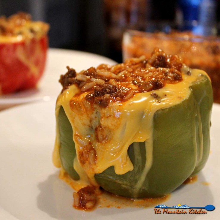 These tender stuffed bell peppers are filled with cheese, Spanish seasoned beef and rice, topped with even more cheese. A classic comfort food favorite! | TheMountainKitchen.com