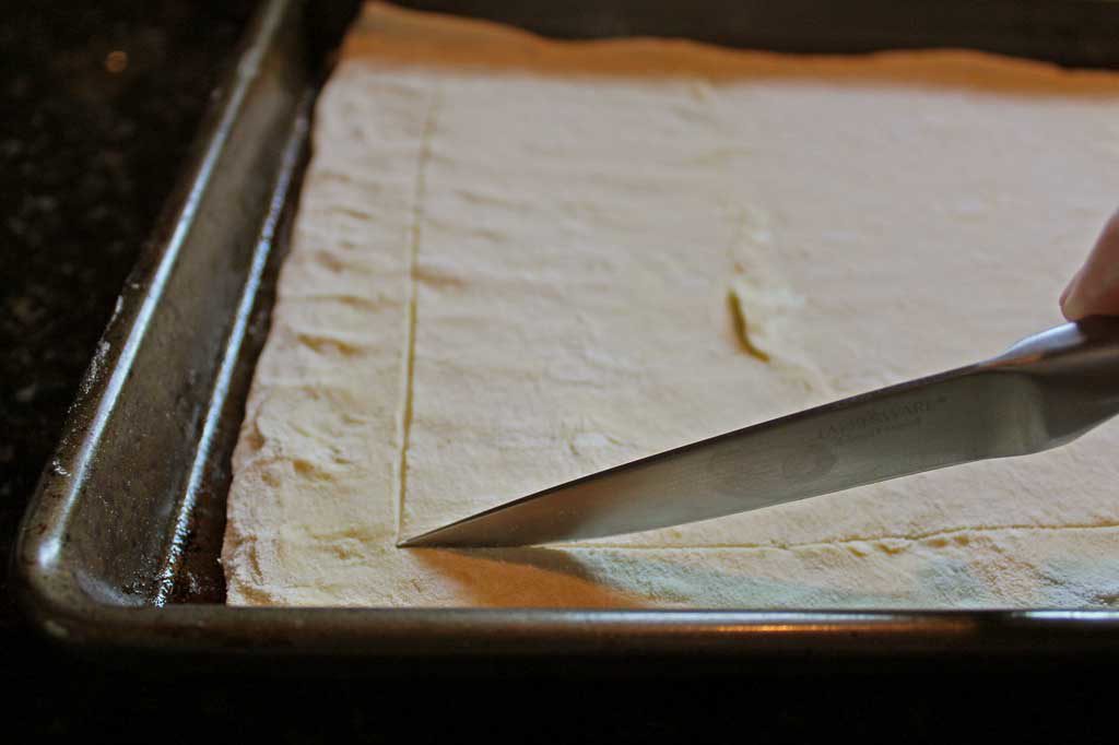 scoring puff pastry dough with a knife