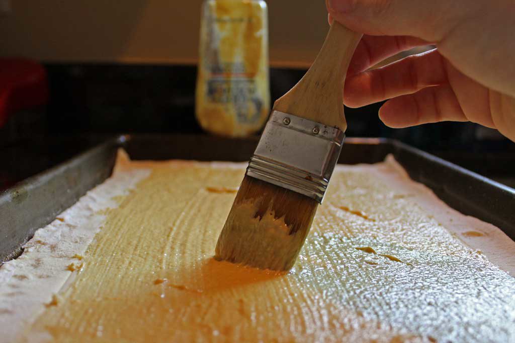 Brushing Dijon Mustard onto puff pastry dough