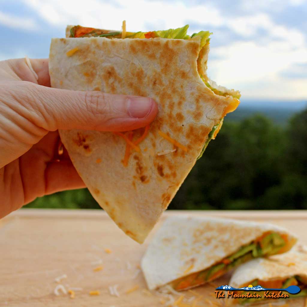 holding wedge of squash blossom quesadilla