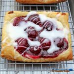 Yum! Enjoy this light, flaky, and easy cherry cream cheese danish with vanilla glaze in the comfort of your home, for breakfast any day of the week. | TheMountainKitchen.com