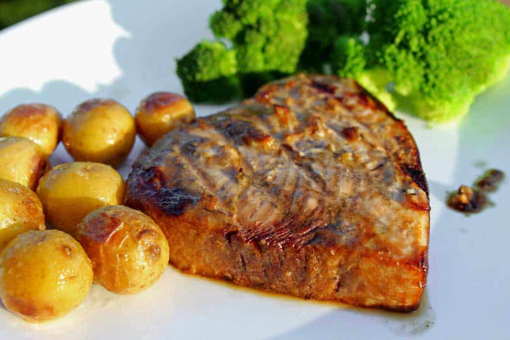 grilled Indonesian swordfish on plate with potatoes and broccoli