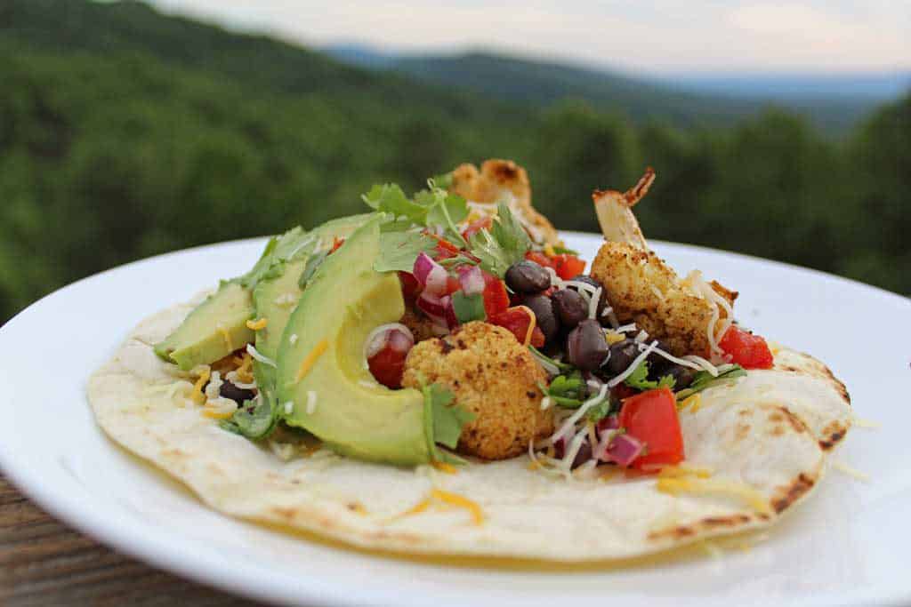 Delicious cauliflower black bean tostadas: roasted cauliflower seasoned with Mexican spices paired with hearty black beans and your choice of toppings! | TheMountainKitchen.com