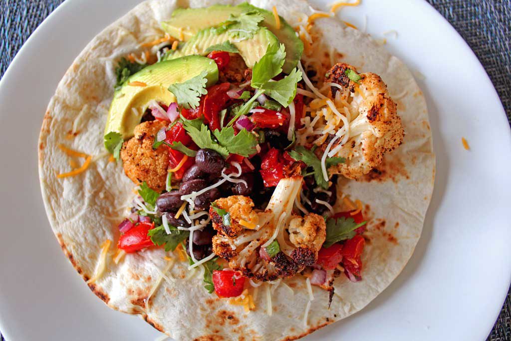 Delicious cauliflower black bean tostadas: roasted cauliflower seasoned with Mexican spices paired with hearty black beans and your choice of toppings! | TheMountainKitchen.com