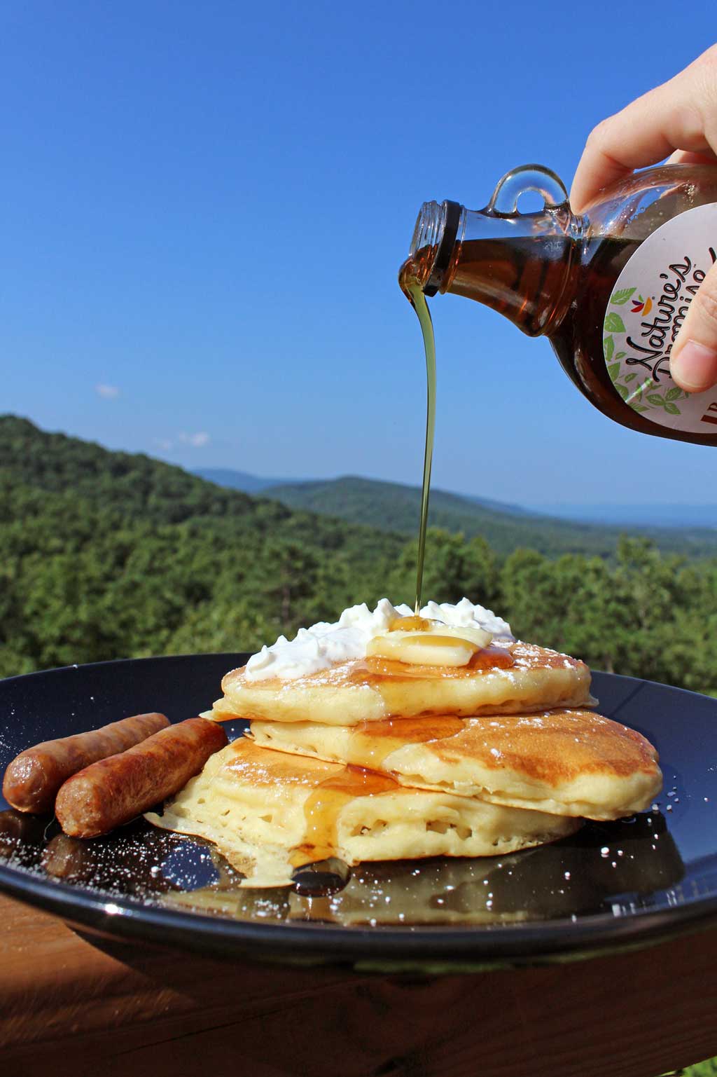 syrup pouring onto stack of pancakes
