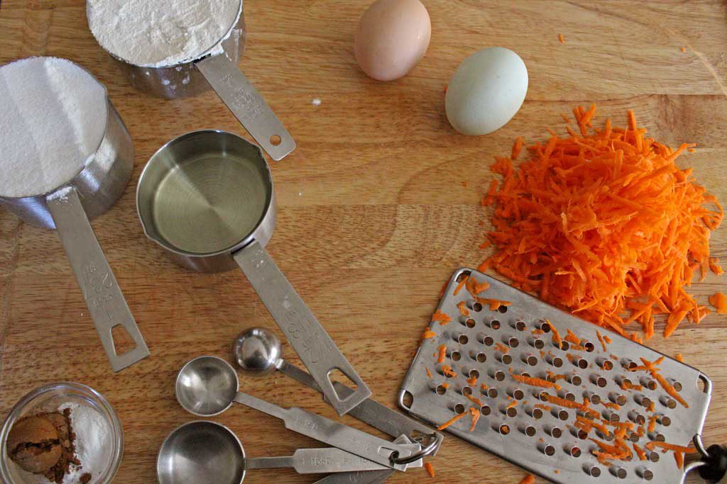 kitchen equipment, shredded carrots and eggs on cutting board