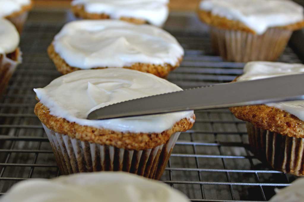 spreading cream cheese on muffin