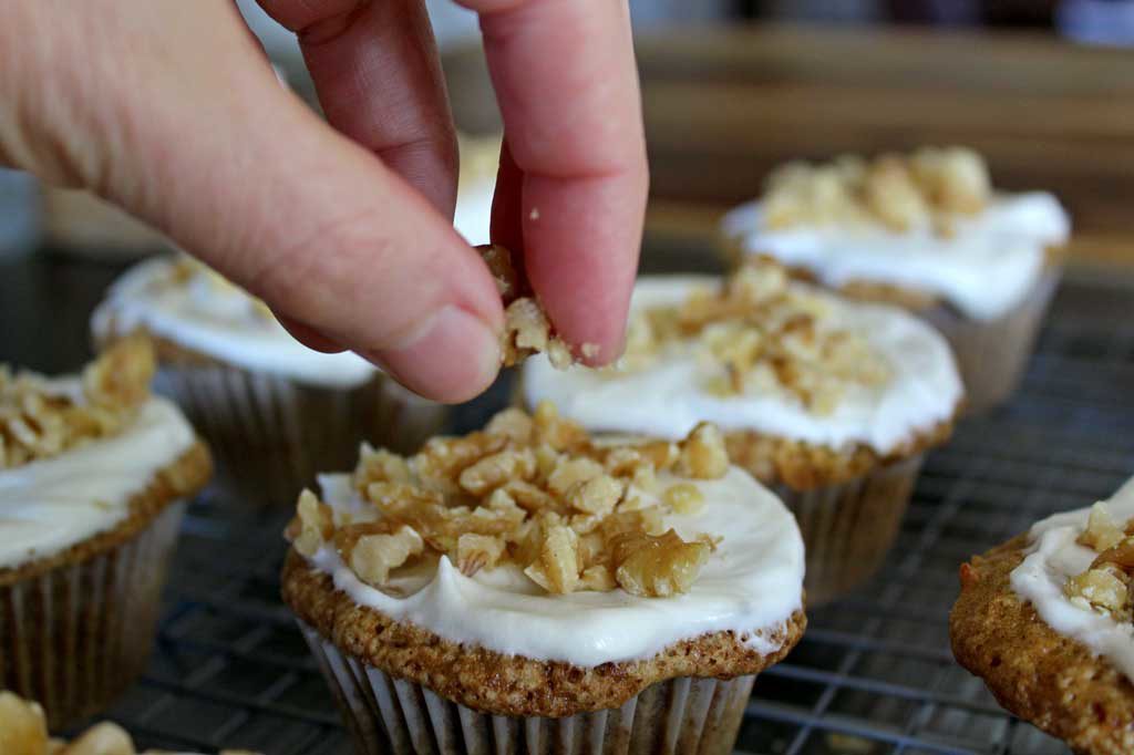 sprinkling chopped walnuts on muffins