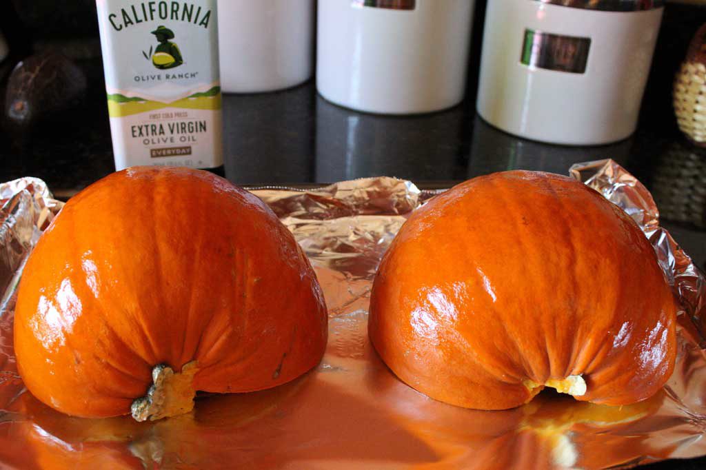 oiled and sliced pumpkin on sheet pan ready to roast