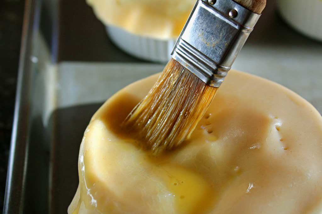 brushing egg wash onto the crust