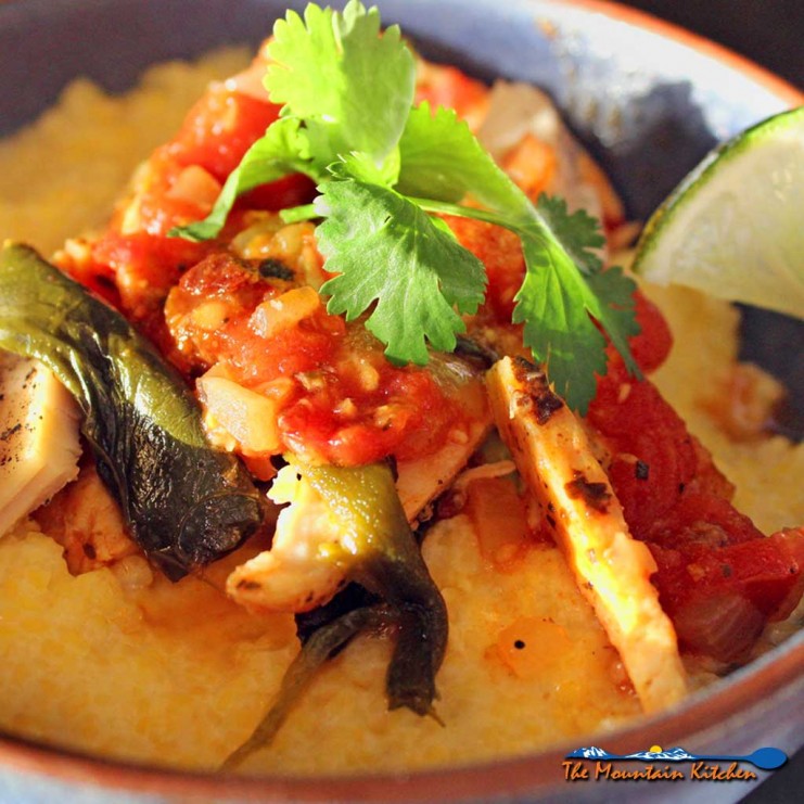 Spicy chicken poblano stew with polenta puts a Mexican spin on Italian food. With only 389 calories per serving, this hearty weeknight dish is made of shredded chicken, stewed with smoky poblanos, and onions in a garlicky tomato sauce spiced up with adobo sauce, served over creamy sweet porridge of polenta. | TheMountainKitchen.com
