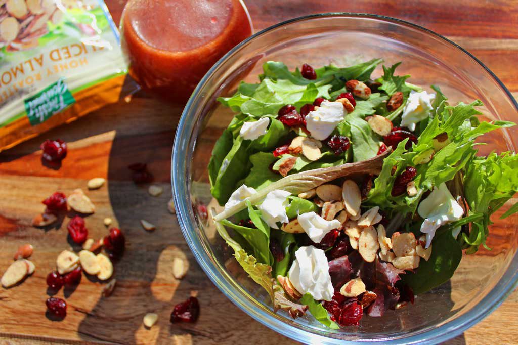 Ready in just 10 minutes, this gorgeous Cranberry-Almond Salad has many delicious and bright flavors, like spring salad greens, sweet cranberries, crunchy almonds and tangy goat cheese drizzled with a delicious homemade raspberry vinaigrette. This simple salad is one you will want to enjoy all year long! | TheMountainKitchen.com