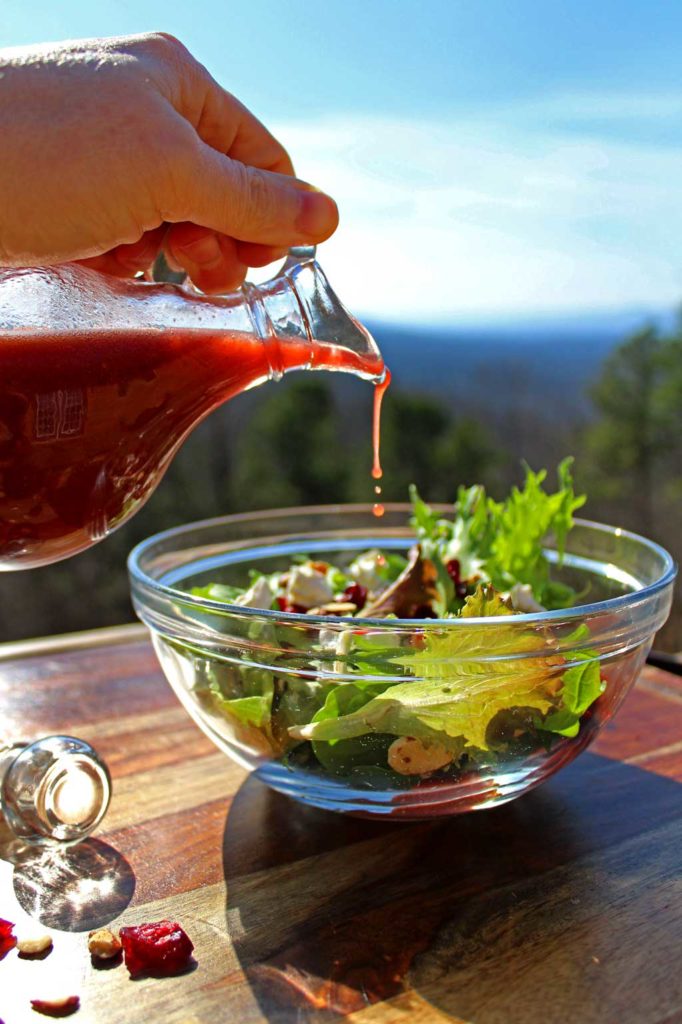 Ready in just 10 minutes, this gorgeous Cranberry-Almond Salad has many delicious and bright flavors, like spring salad greens, sweet cranberries, crunchy almonds and tangy goat cheese drizzled with a delicious homemade raspberry vinaigrette. This simple salad is one you will want to enjoy all year long! | TheMountainKitchen.com
