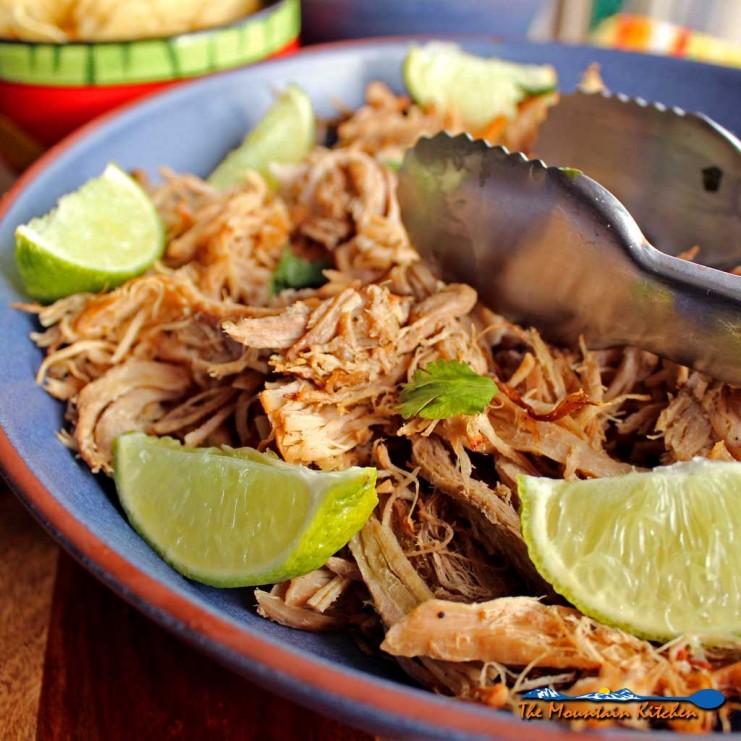 Pork Carnitas are cooked slowly in s rich flavorful broth before putting it into the oven to become crispy and caramelized. The deeply flavorful, melt-in-your-mouth oven-roasted pork carnitas are perfect for filling tacos, burritos or placing on top of nachos with a crunchy, refreshing orange cabbage slaw. | TheMountainKitchen.com