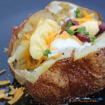 Steakhouse baked potatoes have a salted crispy, golden skin with a light with a warm fluffy center. Learn how to make these perfect baked potatoes at home! | TheMountainKitchen.com
