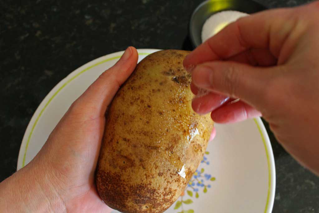 sprinkling salt on potato