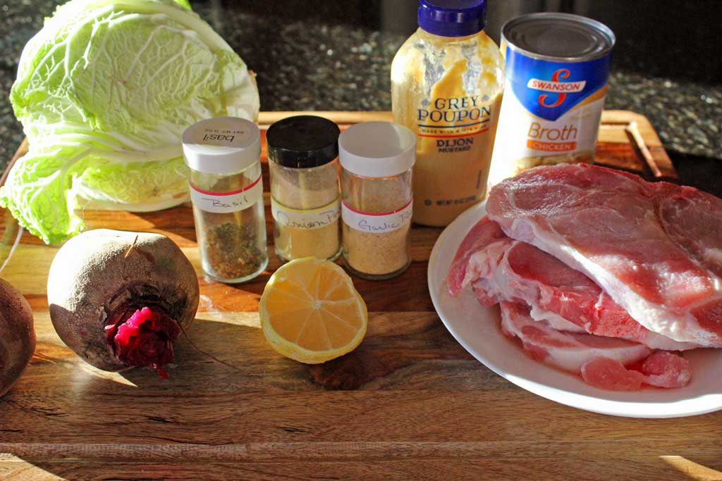 Dijon pork chops dredged in lemony Dijon mustard with herbs, roasted on a bed of cabbage in a rich broth. Try with roasted beets with apple cider vinegar! | TheMountainKitchen.com