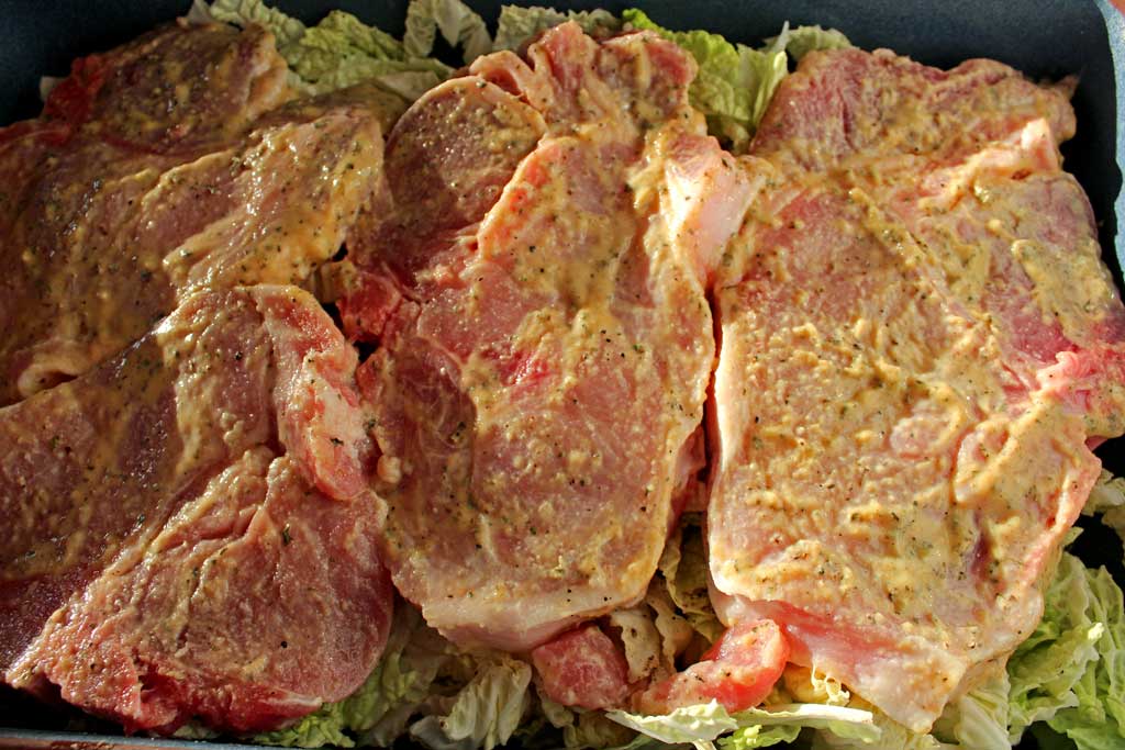 Dijon pork chops dredged in lemony Dijon mustard with herbs, roasted on a bed of cabbage in a rich broth. Try with roasted beets with apple cider vinegar! | TheMountainKitchen.com