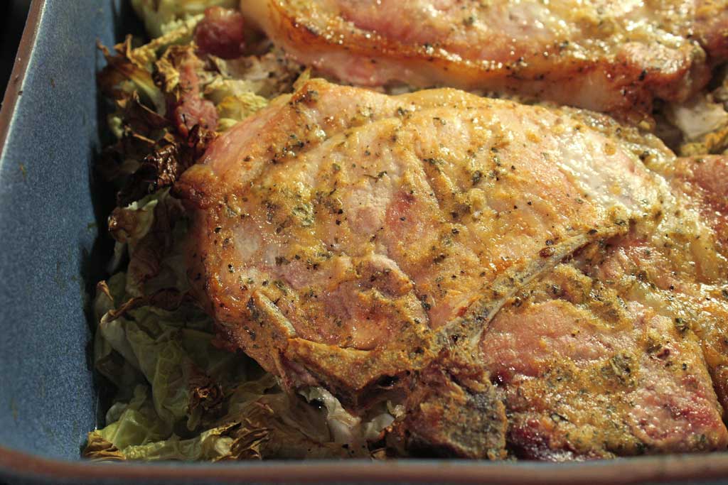 Dijon pork chops dredged in lemony Dijon mustard with herbs, roasted on a bed of cabbage in a rich broth. Try with roasted beets with apple cider vinegar! | TheMountainKitchen.com