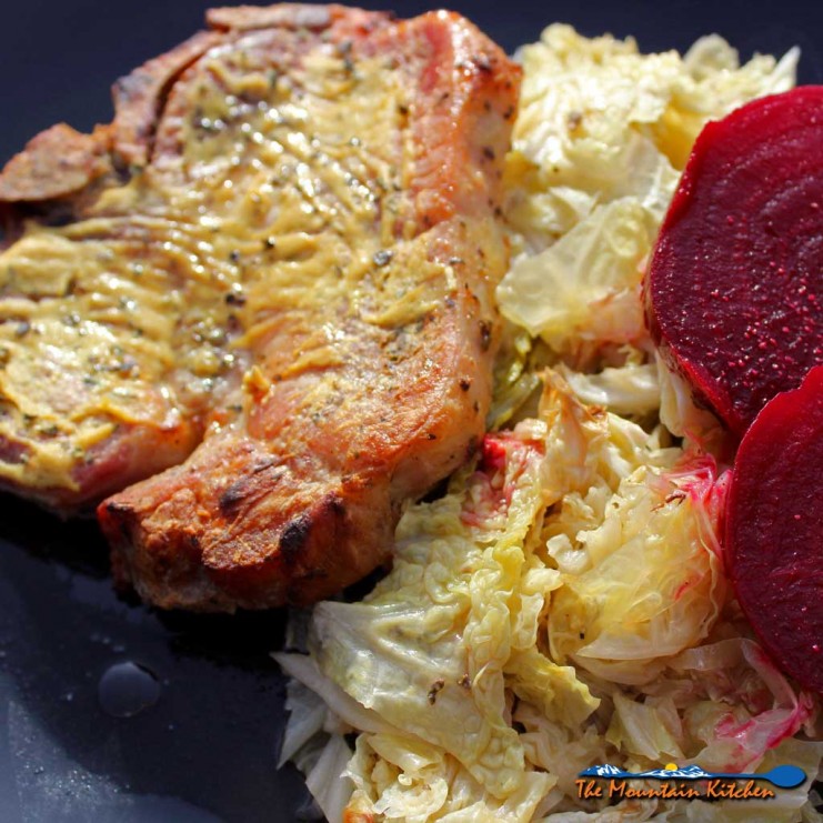 Dijon pork chops dredged in lemony Dijon mustard with herbs, roasted on a bed of cabbage in a rich broth. Try with roasted beets with apple cider vinegar! | TheMountainKitchen.com