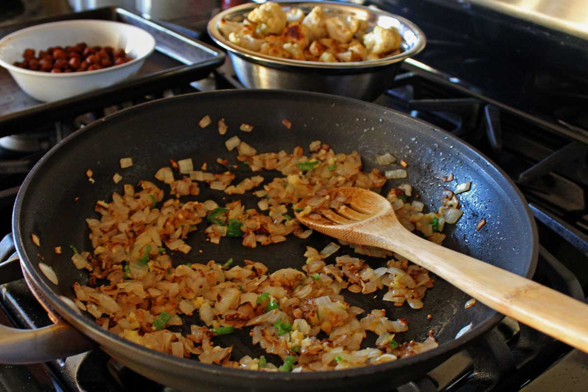 With rich flavors of spice and chilis typically found in Indian cuisine, serve this cauliflower stew with rice and chickpeas. It will leave you spellbound! | TheMountainKitchen.com
