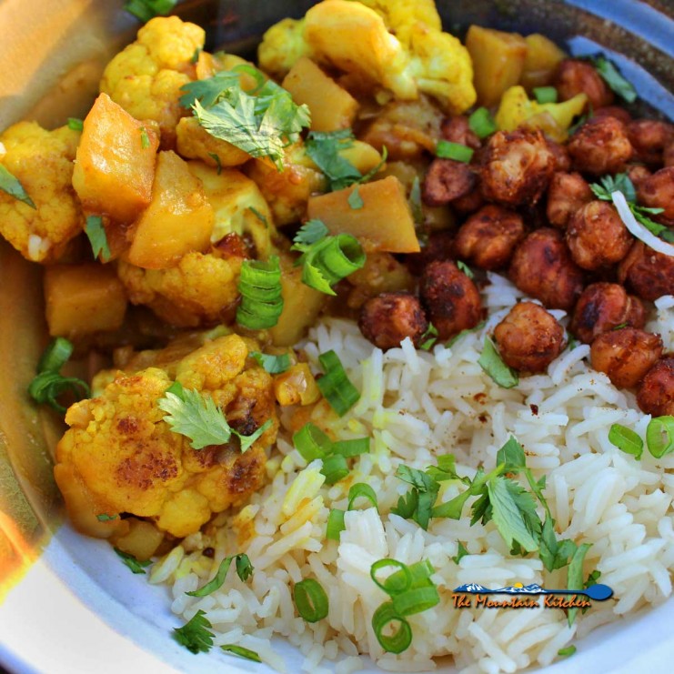 With rich flavors of spice and chilis typically found in Indian cuisine, serve this cauliflower stew with rice and chickpeas. It will leave you spellbound! | TheMountainKitchen.com