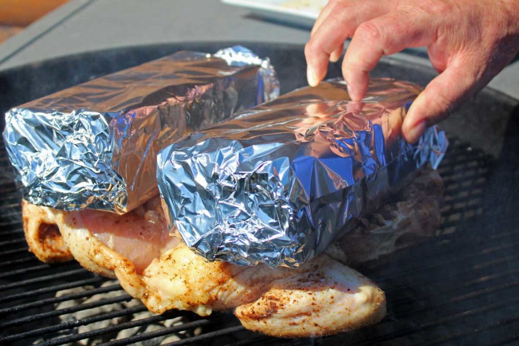 placing foil-wrapped bricks on top of chicken