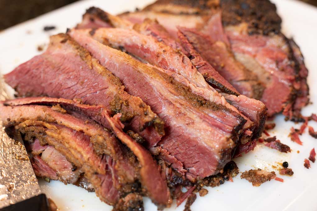 sliced smoked pastrami on cutting board