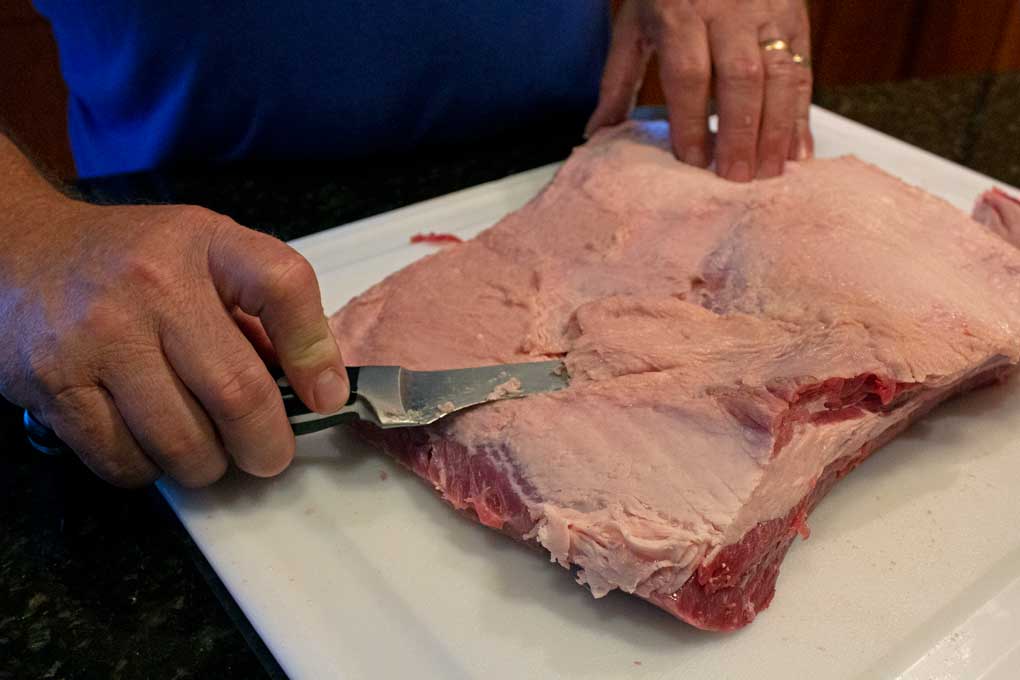 trimming brisket with knife